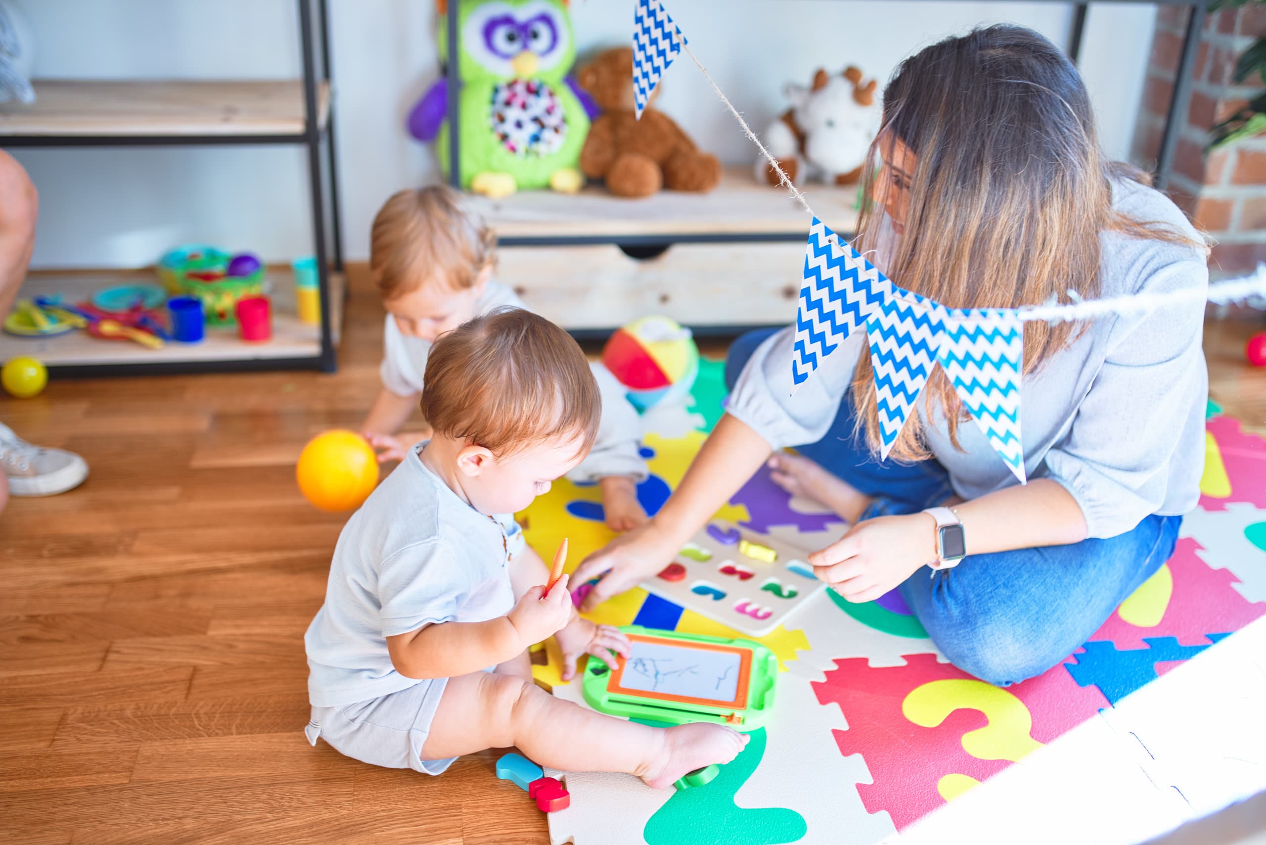 teacher-toddlers-playing-lots-toys